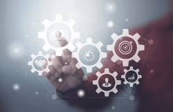 A man using an interface with cogs working together in order to stop the business from struggling to find talent